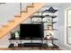 Living room with modern TV console and storage under a floating staircase at 4590 Grove St, Denver, CO 80211