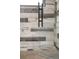 Close-up of shower with glass door, stylish tile work, and metal hardware at 4590 Grove St, Denver, CO 80211