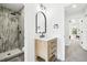 Modern bathroom with an open shower, wood vanity, black fixtures, and an arched mirror at 6722 S Independence St, Littleton, CO 80128