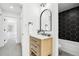 Updated bathroom with a wood vanity, marble countertop, black fixtures, and hexagon tiled shower at 6722 S Independence St, Littleton, CO 80128