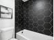 Bathroom featuring modern geometric tiles, a bathtub, and a rainfall shower head at 6722 S Independence St, Littleton, CO 80128