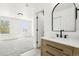 Bright bathroom with a wood vanity, white countertop, and black fixtures near the bedroom at 6722 S Independence St, Littleton, CO 80128