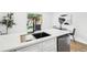 Modern kitchen featuring white cabinets, stainless steel appliances, a matte black sink, and a view to the exterior at 6722 S Independence St, Littleton, CO 80128