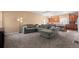 Open-concept living room adjacent to the kitchen, carpet floors, and modern lighting fixtures at 9626 E 105Th Pl, Commerce City, CO 80640