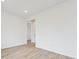 Minimalist bedroom featuring wood-look floors, neutral walls, and a doorway leading to another room at 24780 E 39Th Ave, Aurora, CO 80019