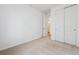 A simple bedroom featuring neutral carpet, white walls, closet and a doorway to the ensuite bathroom at 24780 E 39Th Ave, Aurora, CO 80019
