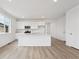 Modern kitchen with white cabinets, quartz countertops, stainless steel appliances, and wood-look floors at 24780 E 39Th Ave, Aurora, CO 80019