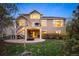 Exterior view of a tan two-story house with a deck, patio, and a manicured lawn at 7284 Timbercrest Ln, Castle Pines, CO 80108