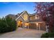 Beautiful two-story home with a stone archway, three car garage, and meticulously maintained landscaping at 7284 Timbercrest Ln, Castle Pines, CO 80108