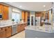 Well-equipped kitchen featuring wood cabinetry, granite countertops, and stainless steel appliances at 7284 Timbercrest Ln, Castle Pines, CO 80108
