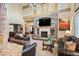 Open-concept living room with a stone fireplace and a view of the entryway and dining area at 7284 Timbercrest Ln, Castle Pines, CO 80108