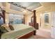 Primary bedroom featuring a four-poster bed and large windows with backyard views at 7284 Timbercrest Ln, Castle Pines, CO 80108