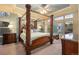 Primary bedroom showcasing a four-poster bed, ceiling fan, and large windows at 7284 Timbercrest Ln, Castle Pines, CO 80108