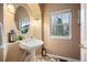 Stylish powder room with a pedestal sink and decorative mirror at 7284 Timbercrest Ln, Castle Pines, CO 80108