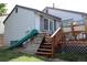 Backyard featuring a green slide, climbing wall, and a wooden deck for outdoor fun and entertainment at 7988 S Johnson Ct, Littleton, CO 80128