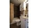 Cozy bathroom featuring a bathtub, a dark wood-look tiled shower, and a white vanity with modern fixtures at 7988 S Johnson Ct, Littleton, CO 80128
