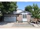 Charming two-story home featuring a brick facade, well-maintained landscaping, and an attached two-car garage at 7988 S Johnson Ct, Littleton, CO 80128