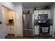Well-lit kitchen featuring stainless steel appliances, white cabinetry, and hardwood floors, creating a clean and efficient cooking space at 7988 S Johnson Ct, Littleton, CO 80128