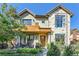 Two-story home with stone and wood accents, a balcony, and a landscaped front yard at 1237 S Saint Paul St, Denver, CO 80210