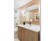 Stylish bathroom with a wood vanity, white countertop, modern fixtures, and updated wall mirror at 12212 W 16Th Dr, Lakewood, CO 80215
