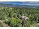 Stunning aerial shot of a home nestled within a forest, featuring mountain views in the background at 2880 Lake Meadow Dr, Monument, CO 80132