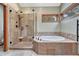 Luxurious bathroom featuring a large shower with tile surround and a soaking tub with tile accents at 2880 Lake Meadow Dr, Monument, CO 80132