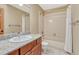 Neutral-toned bathroom with tiled shower over tub, wooden vanity, and granite countertop at 2880 Lake Meadow Dr, Monument, CO 80132