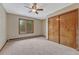 Cozy bedroom with a ceiling fan, carpet floors, and a closet with wood doors at 2880 Lake Meadow Dr, Monument, CO 80132