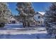 Charming home exterior with snow covered yard, detached garage and mature trees at 2880 Lake Meadow Dr, Monument, CO 80132