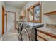 Modern laundry room with stainless steel washer and dryer and granite countertops at 2880 Lake Meadow Dr, Monument, CO 80132
