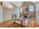 Bright living room with hardwood flooring, stone fireplace, and soaring windows at 2880 Lake Meadow Dr, Monument, CO 80132