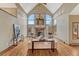 Bright living room with hardwood flooring, stone fireplace, and soaring windows at 2880 Lake Meadow Dr, Monument, CO 80132