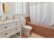 Cozy bathroom featuring a white vanity, toilet, and tiled bathtub with shower at 1765 S Franklin St, Denver, CO 80210