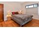 Comfortable bedroom with hardwood floors, window with blinds, and unique leopard print bedspread at 1765 S Franklin St, Denver, CO 80210