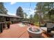 Relaxing back deck featuring an outdoor dining set and modern fire pit at 29663 Paint Brush Dr, Evergreen, CO 80439