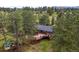 Aerial view of large backyard deck and patio set, surrounded by lush trees at 29663 Paint Brush Dr, Evergreen, CO 80439