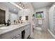 Well-lit bathroom featuring double sinks, marble countertops, and a window at 29663 Paint Brush Dr, Evergreen, CO 80439