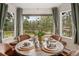Charming dining area with bright windows and views of the trees and decorative table setting at 29663 Paint Brush Dr, Evergreen, CO 80439