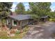 Exterior of home featuring a sunroom with expansive windows, a driveway, and a landscaped yard at 29663 Paint Brush Dr, Evergreen, CO 80439