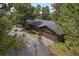 Aerial view of the home showcasing a two-car garage, beautiful trees, and a basketball hoop at 29663 Paint Brush Dr, Evergreen, CO 80439