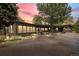 Charming single-story home with a paved driveway, mature trees, and beautifully landscaped front yard at sunset at 29663 Paint Brush Dr, Evergreen, CO 80439
