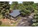 Home exterior with a sunroom and brick chimney is surrounded by well-manicured landscaping and mature trees at 29663 Paint Brush Dr, Evergreen, CO 80439