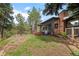 Charming single-Gathering home with a brick chimney and wooden deck, nestled among lush trees at 29663 Paint Brush Dr, Evergreen, CO 80439