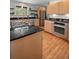 Modern kitchen featuring stainless steel appliances, wood cabinets, granite countertops, and tiled backsplash at 29663 Paint Brush Dr, Evergreen, CO 80439