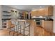 Modern kitchen featuring wood cabinets, black countertops, stainless steel appliances, and breakfast bar with stools at 29663 Paint Brush Dr, Evergreen, CO 80439