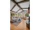 Bright living room featuring vaulted ceilings, exposed beams, a stone fireplace and scenic backyard views at 29663 Paint Brush Dr, Evergreen, CO 80439