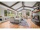 Bright living room featuring vaulted ceilings, exposed beams, a stone fireplace and scenic backyard views at 29663 Paint Brush Dr, Evergreen, CO 80439