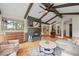 Inviting living room featuring vaulted ceilings, exposed beams, a stone fireplace and open floor plan at 29663 Paint Brush Dr, Evergreen, CO 80439