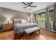 Cozy main bedroom with hardwood floors, neutral walls, a bench at the foot of the bed, and natural light at 29663 Paint Brush Dr, Evergreen, CO 80439