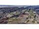 Aerial view of a golf course surrounded by homes and red rocks at 6931 Buckskin Dr, Littleton, CO 80125